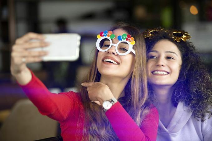 chicas divertidas tomándose selfies en la celebración del cumpleaños