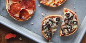 pizzas de bagel en una bandeja con una variedad de ingredientes