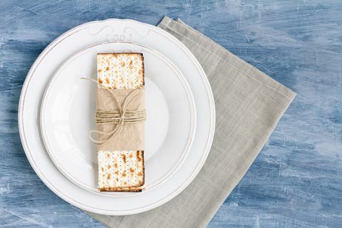 plato blanco con matzah o matza sobre un fondo de mesa vintage presentado como una fiesta o comida de seder de pascua