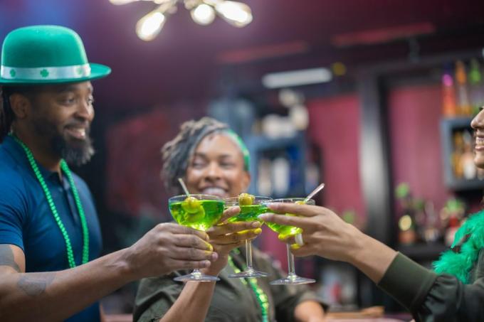 tres amigos tintineando martinis verdes en el día de San Patricio podrías llamar irlandés hoy, resaca mañana