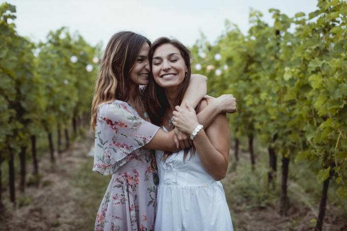 hermanas gemelas abrazándose en un picnic de verano en un viñedo