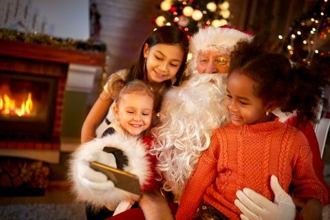 Santa Claus compartiendo teléfonos inteligentes con niños