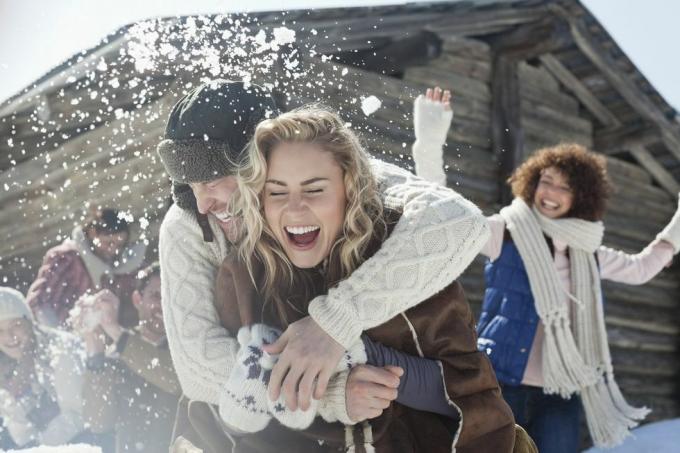 amigos adultos lanzando bolas de nieve, paseo a cuestas