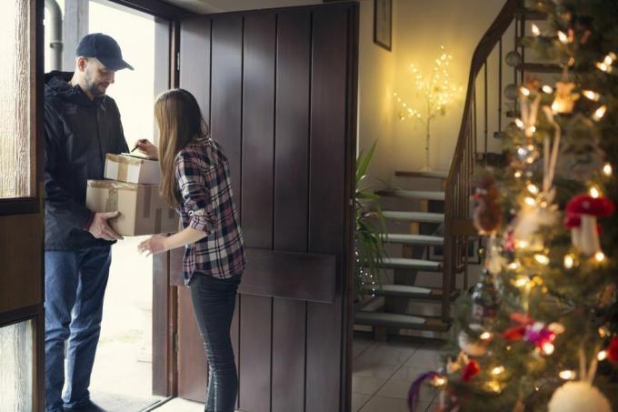 adolescente recibiendo paquetes de navidad entregados por cartero