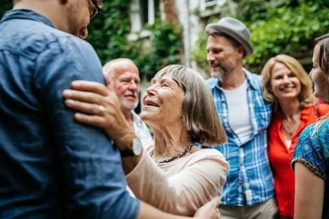 Anciana saludando a miembros de la familia en el patio