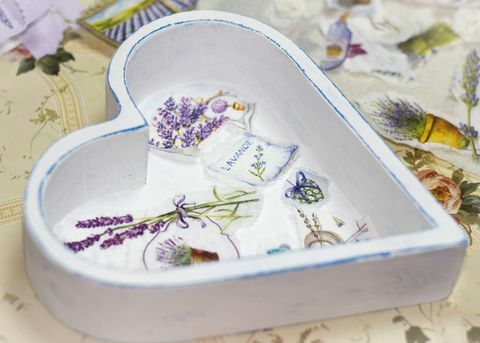 caja de madera blanca en forma de corazón, con imágenes de decoupage de lavanda en la parte inferior y papel recortado a su alrededor