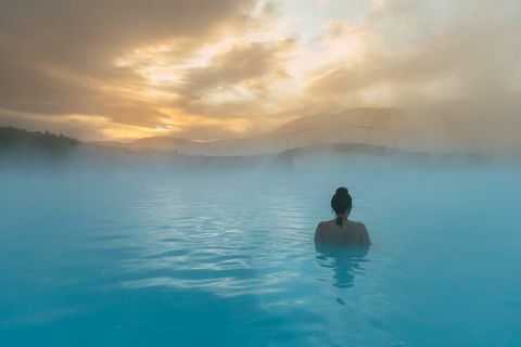 vista trasera, de, un, mujer estar de pie, en, el, laguna azul, islandia