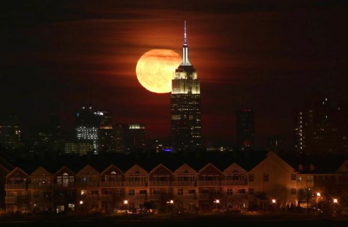 La luna llena sale detrás del Empire State Building en la ciudad de Nueva York