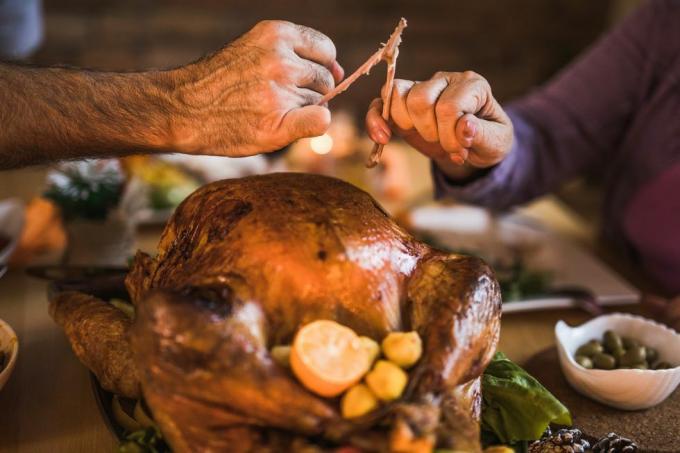 Cerca de personas irreconocibles tirando de la espoleta durante la cena de acción de gracias en la mesa del comedor.