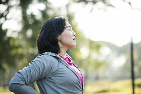 descanso y recuperación después del ejercicio vista lateral de las mujeres trabajadoras asiáticas descansan después de hacer ejercicio al aire libre en un parque de la ciudad