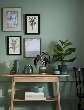 habitación elegante con pintura verde y aparador de madera