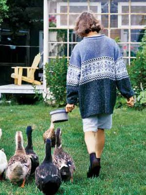 mujer en patio con patos