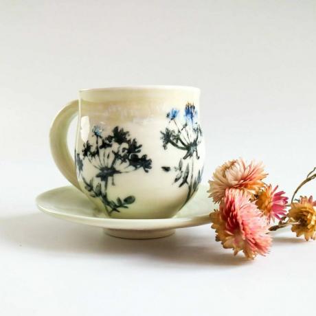Taza y platillo de porcelana con diseño de flores de seto