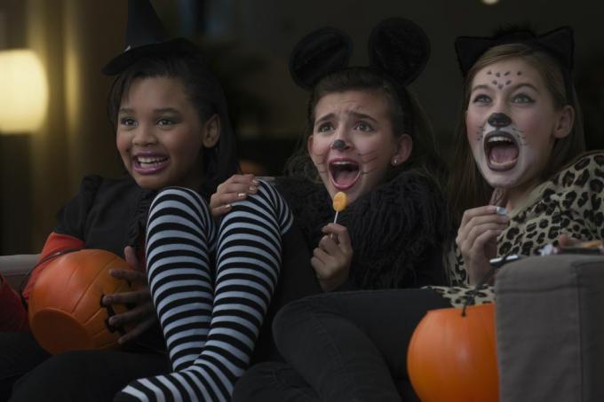 chicas disfrazadas viendo películas de miedo juntas en halloween