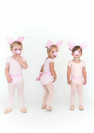 niñas en medias rosas y mamelucos con orejas de cerdo y hocicos de cerdo