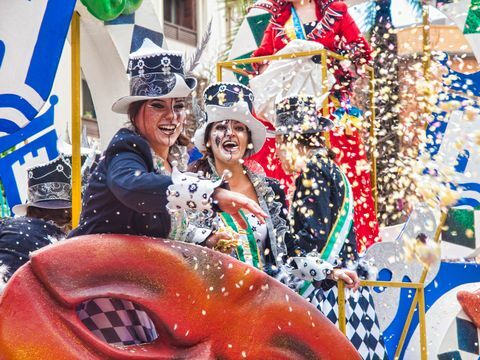 algeciras alegres participantes del carnaval riéndose lanzan confeti durante el desfile del carnaval en la calle en algeciras, cádiz, andalucía