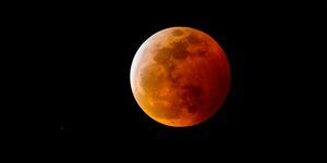 una luna de sangre, o luna llena con una sombra rojiza debido a un eclipse lunar total, en el cielo nocturno