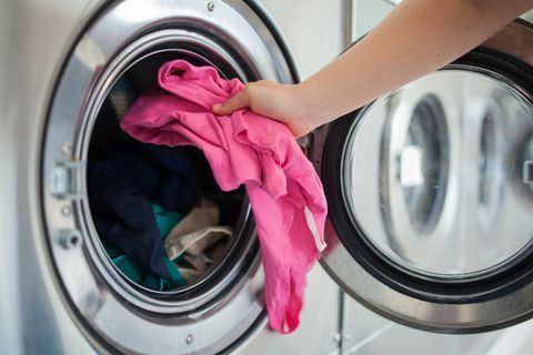 mujer poniendo la camisa en la lavadora