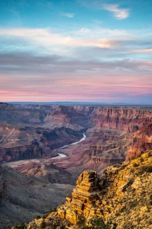 vista panorámica del parque nacional del gran cañón con la puesta de sol en el fondo y el río que fluye a través de él