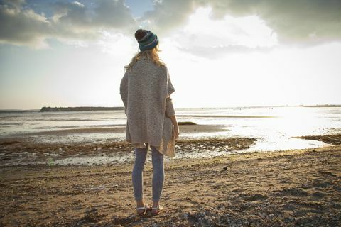 Mujer joven mirando en la playa de Bournemouth, Dorset, Reino Unido