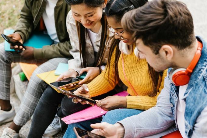 diversos jóvenes estudiantes adolescentes divirtiéndose usando teléfonos móviles en la educación del campus universitario, personas milenarias y concepto de redes sociales