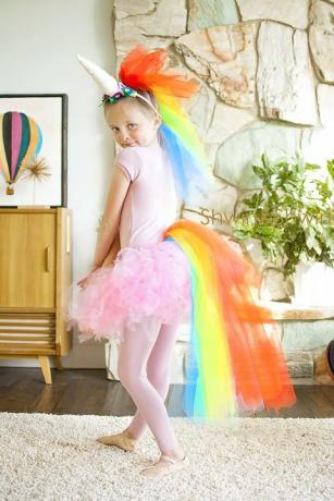 niña vestida con tutú rosa y mallas, con tul multicolor para una cola y melena, y un cuerno de unicornio