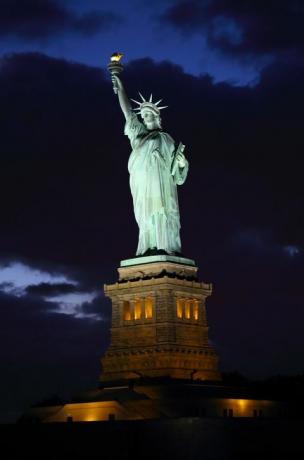 toma iluminada de la estatua de la libertad al atardecer