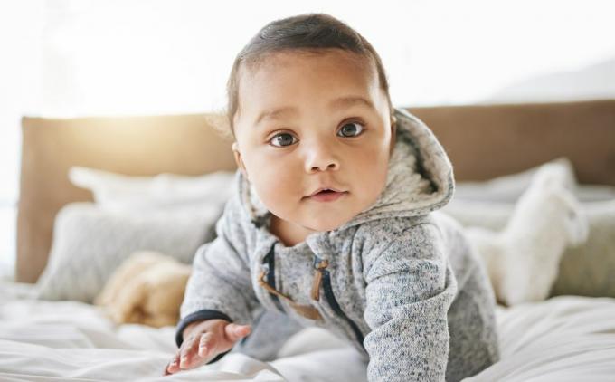 foto de un adorable bebé jugando en la cama en casa