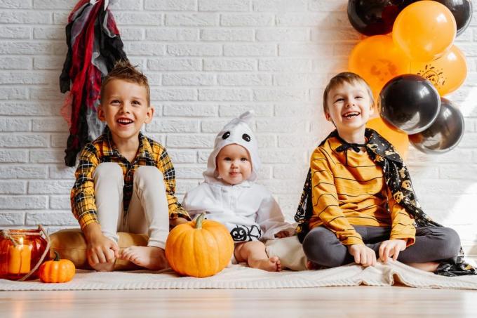 niños disfrazados celebran halloween pared de ladrillo blanco con decoraciones copia espacio