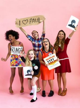 cinco mujeres vestidas como beatlemaníacos con ropa vintage riendo y gritando, una sostiene el álbum de los beatles