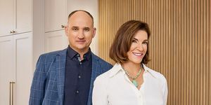 presenta a hilary farr y david visentin de pie en la cocina revelada, sonriendo